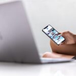 A woman multitasks using a smartphone and laptop, symbolizing modern digital nomad lifestyle in Bali.